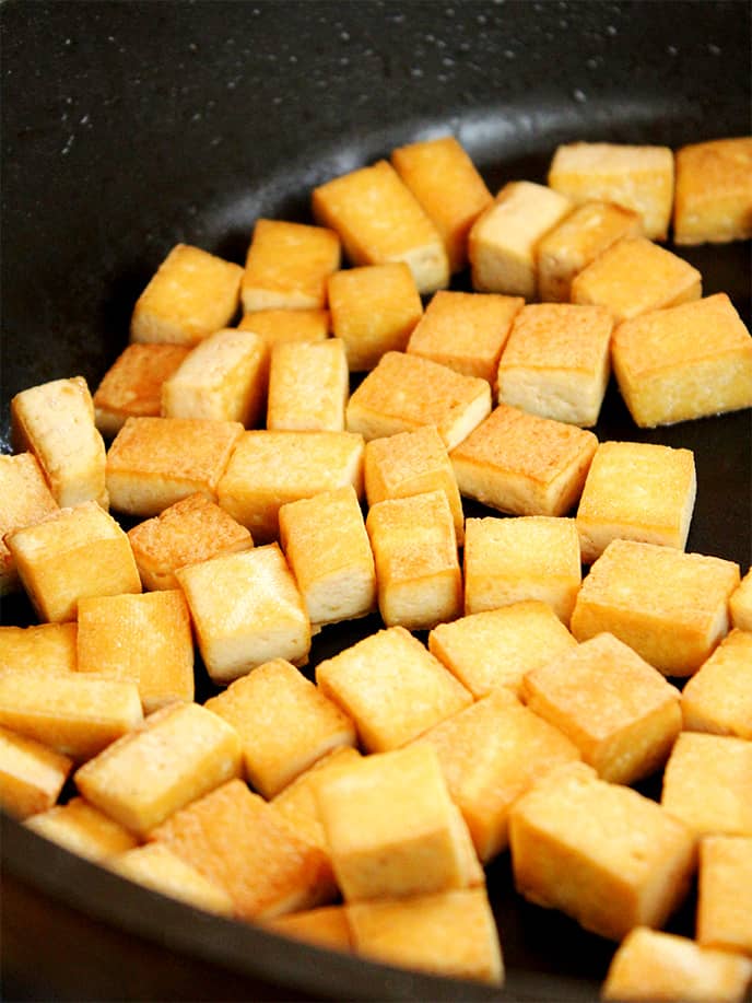 Pan-frying crispy tofu to make Teriyaki Peanut Tofu with Stir-Fried Veggies & Brown Rice.