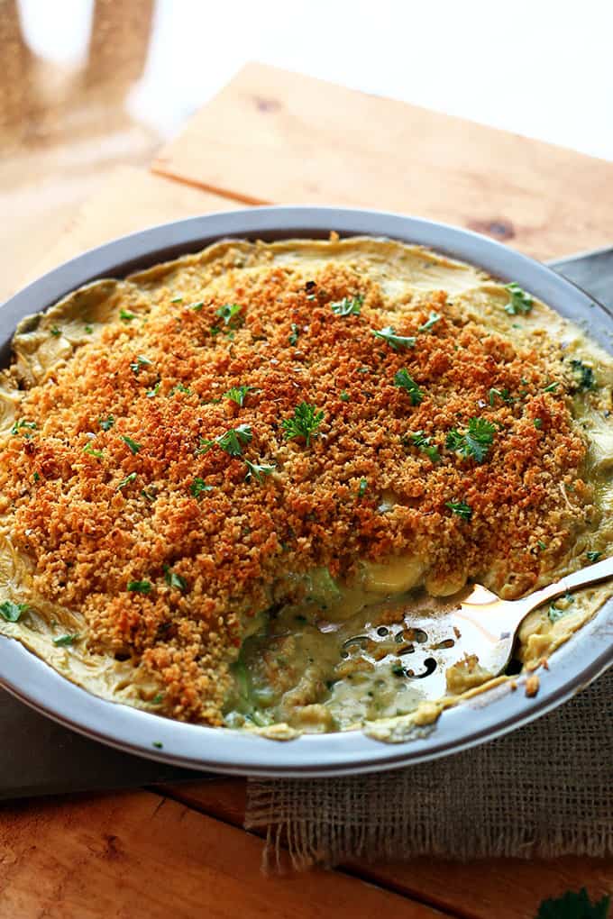 Cheesy Vegan Potato & Broccoli Casserole with a serving spoon and one portion already served.