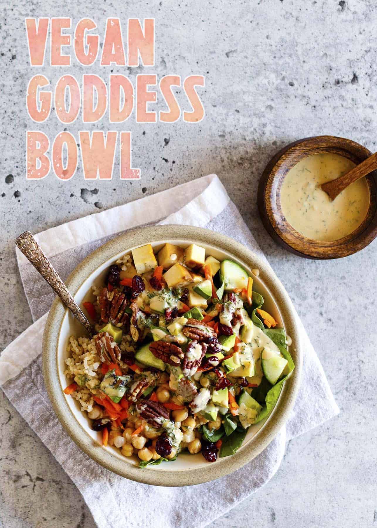 Vegan Goddess Bowl with Tahini Dressing on a concrete background with typography overlay.
