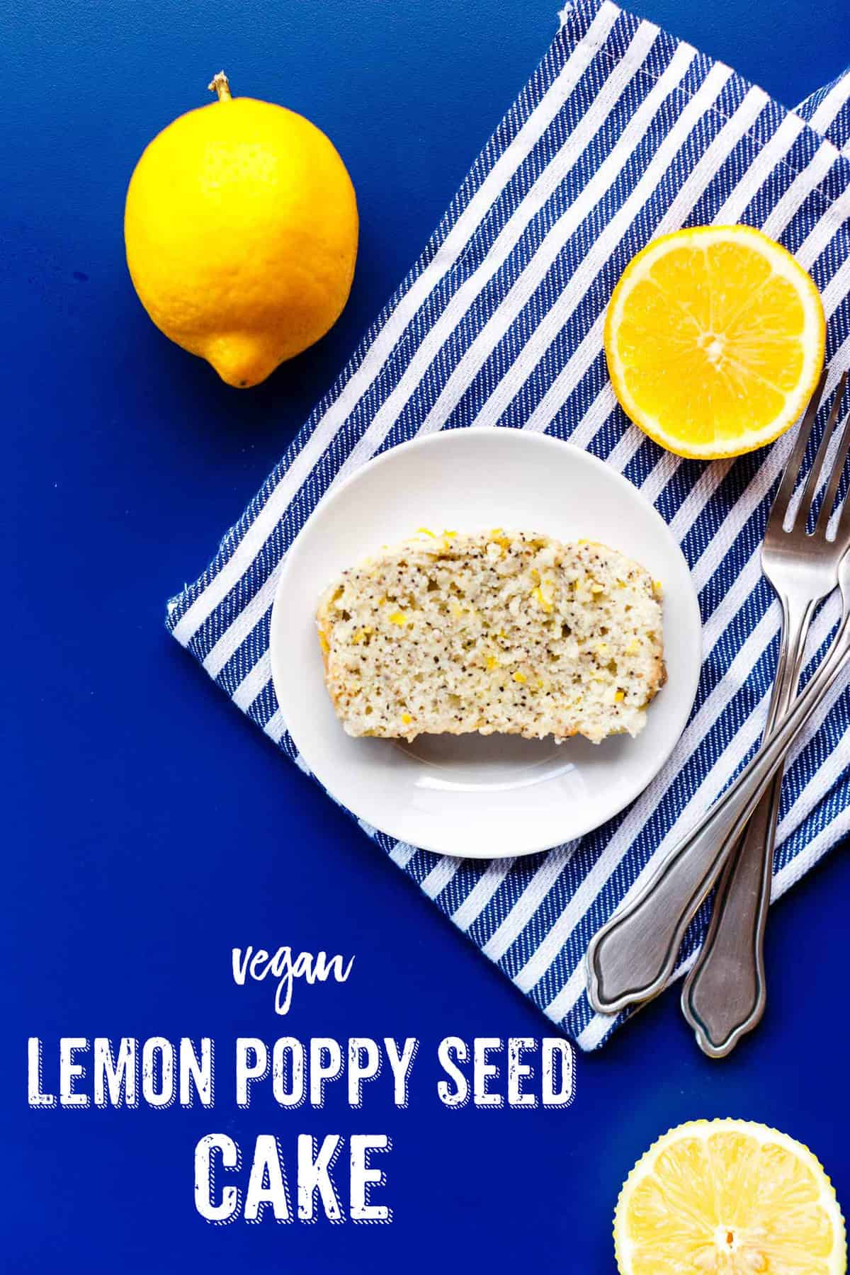 A slice of Vegan Lemon Poppy Seed Cake on a striped kitchen towel.