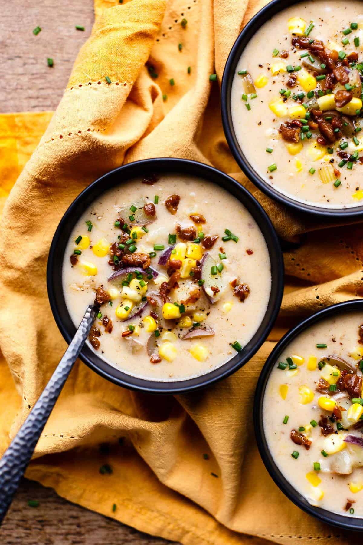 Close up of a bowl of Vegan Instant Pot Little Potato & Corn Chowder on a yellow kitchen towel.