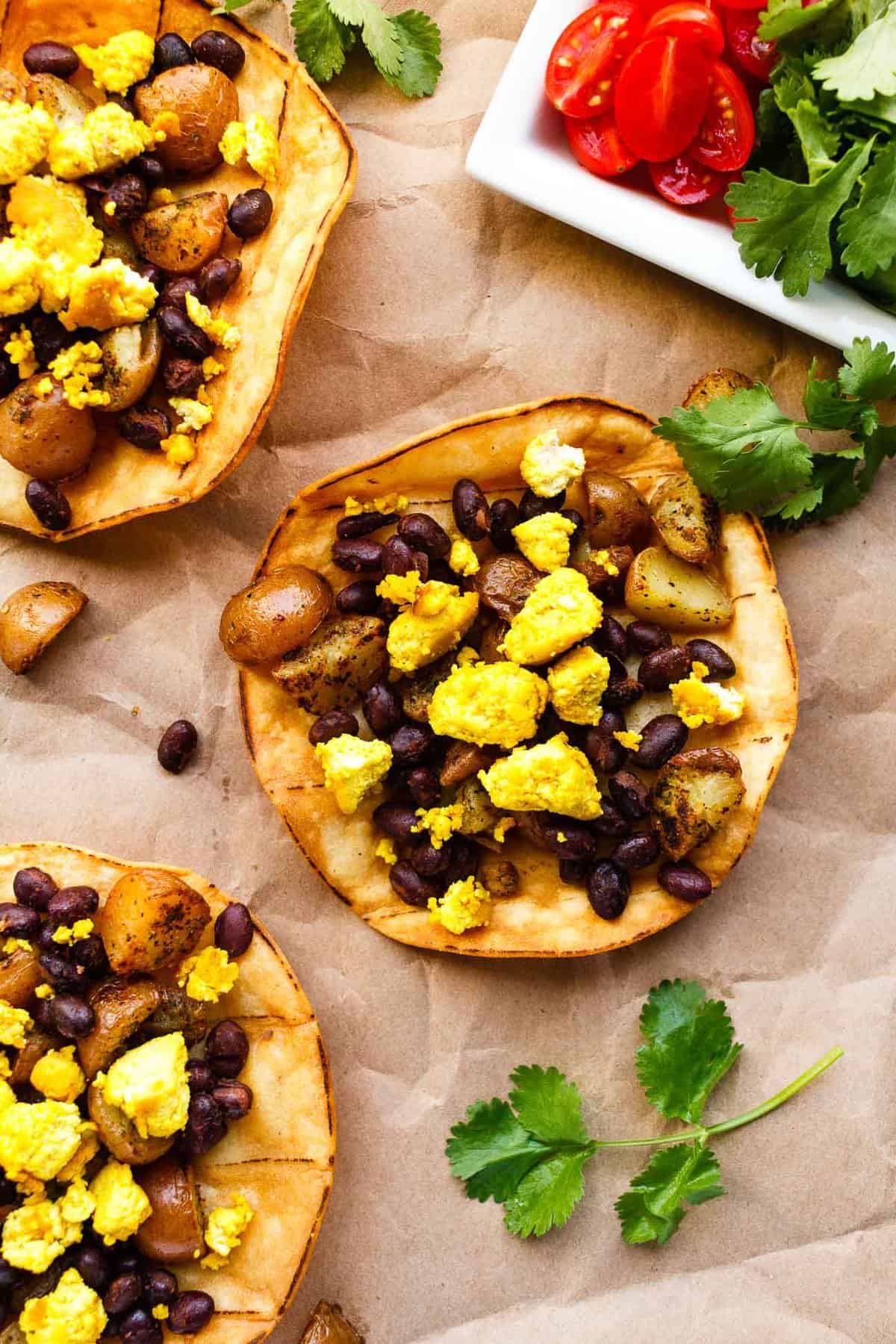 Vegan breakfast tostadas stopped with seasoned Creamer potatoes, spicy black beans, and scrambled tofu.