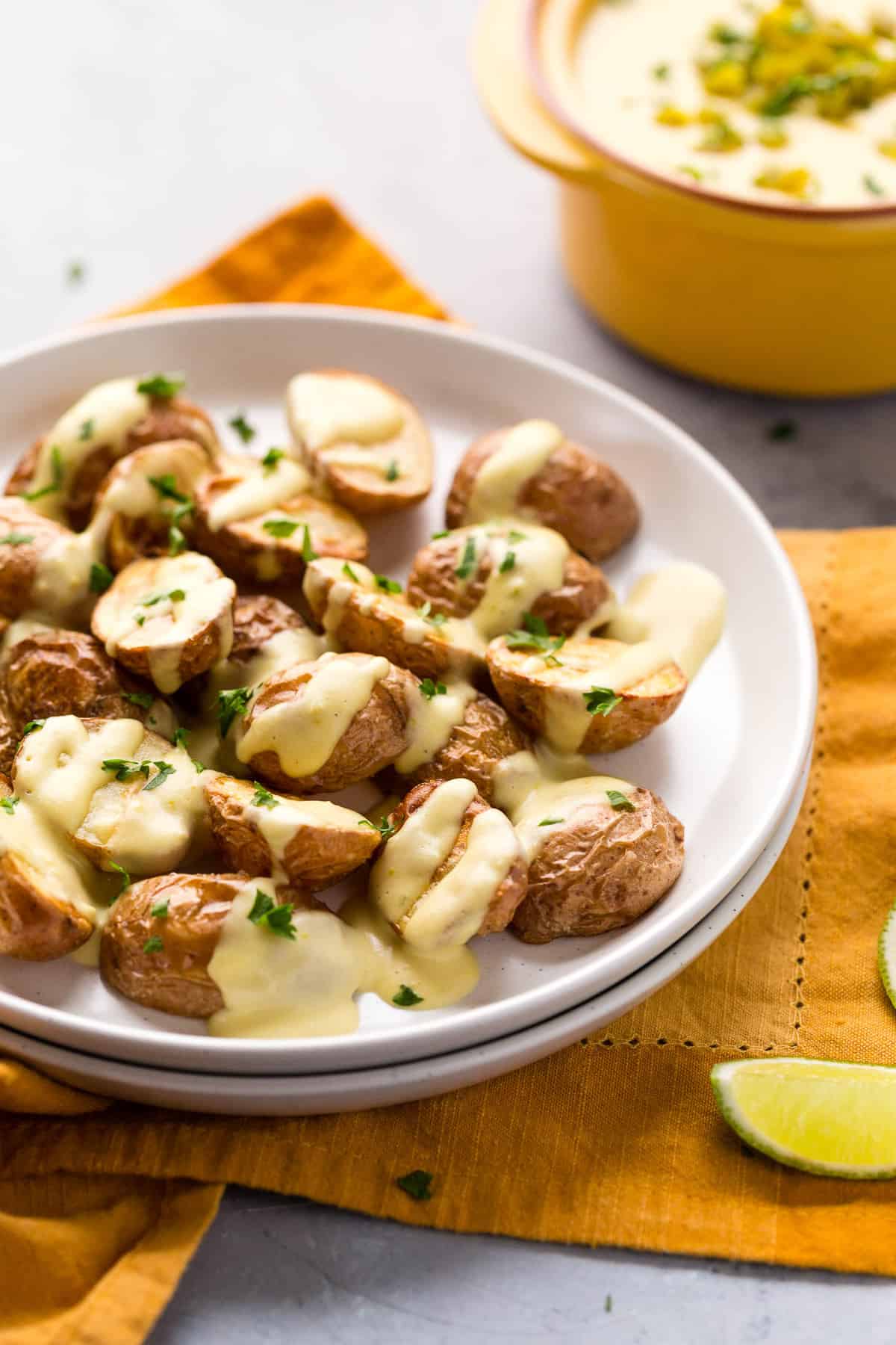 Roasted potatoes drizzled with vegan queso and sprinkled with fresh herbs.