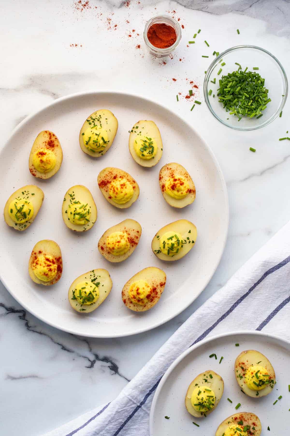 Vegan deviled egg potatoes garnished with paprika and fresh chives.