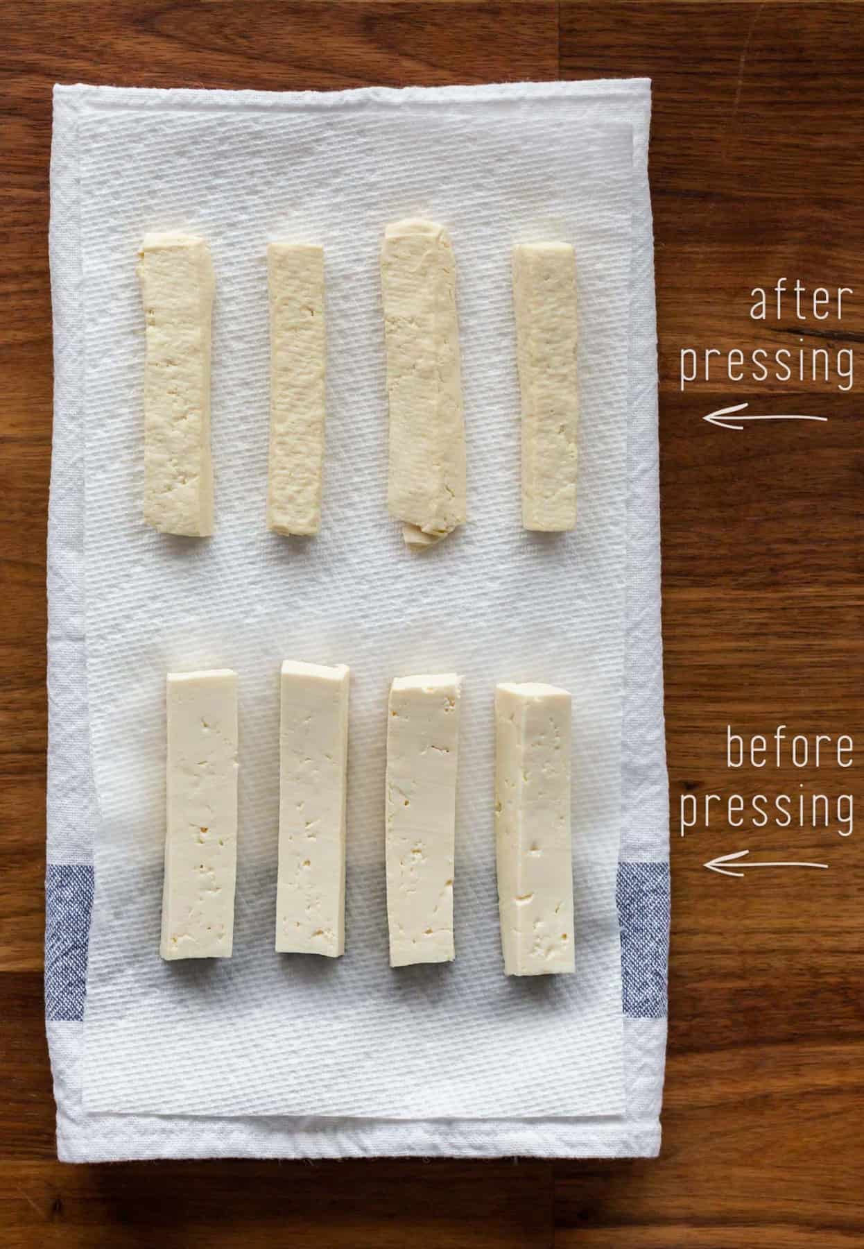 Medium-firm tofu cut into rectangles laying on a kitchen towel. Top row shows pressed tofu (dry to the touch and barely beginning to crumble). Bottom row shows silky, unpressed medium-firm tofu.