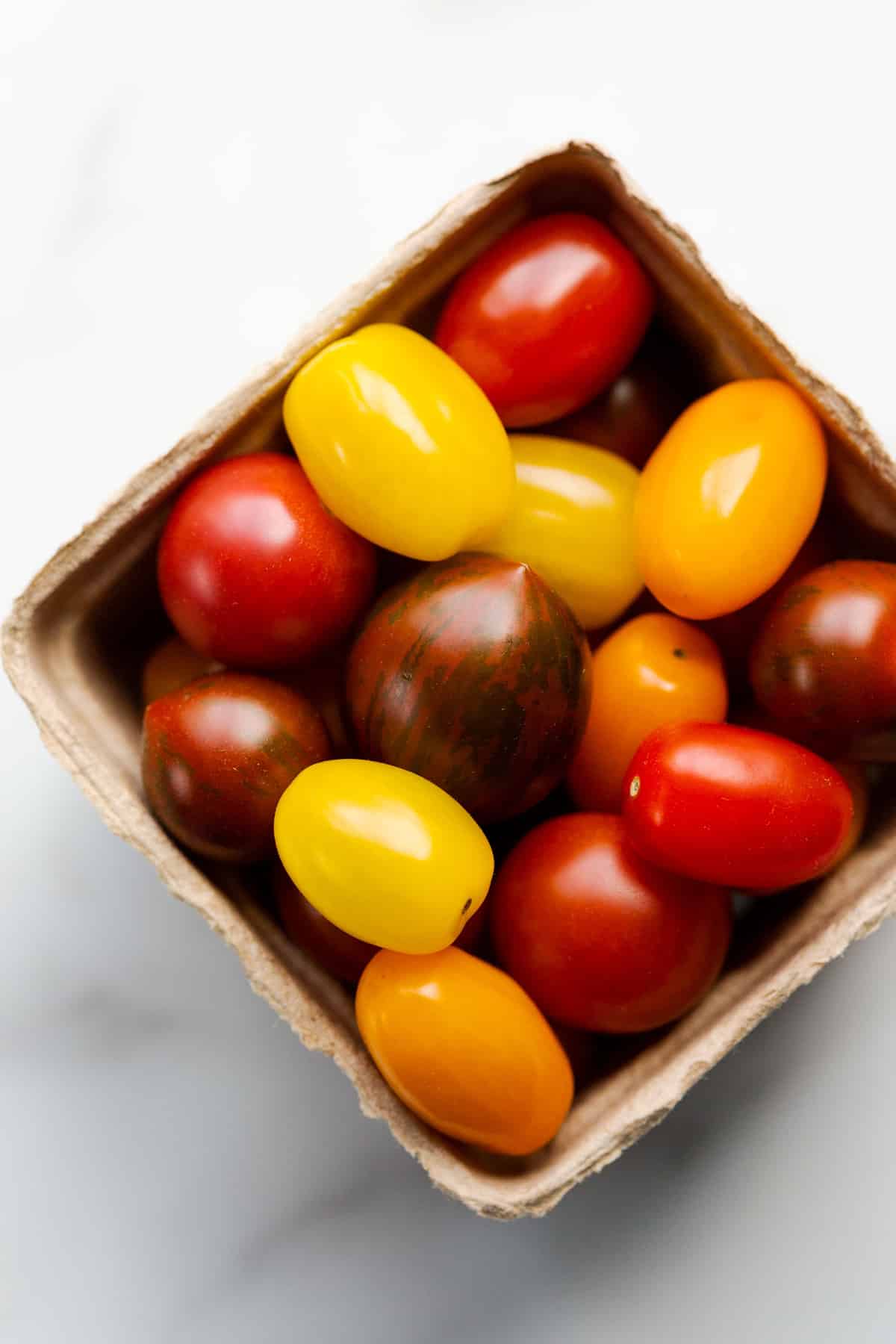 A carton of colourful mixed summer tomatoes.