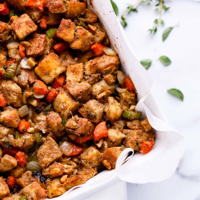 Vegan vegetable stuffing in a white casserole dish.