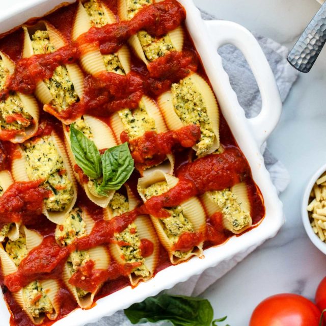 Basil Tofu "Ricotta" Stuffed Shells on a marble countertop.