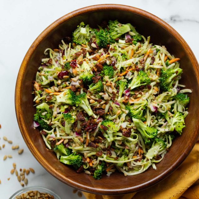 Vegan broccoli slaw in a wooden serving bowl.